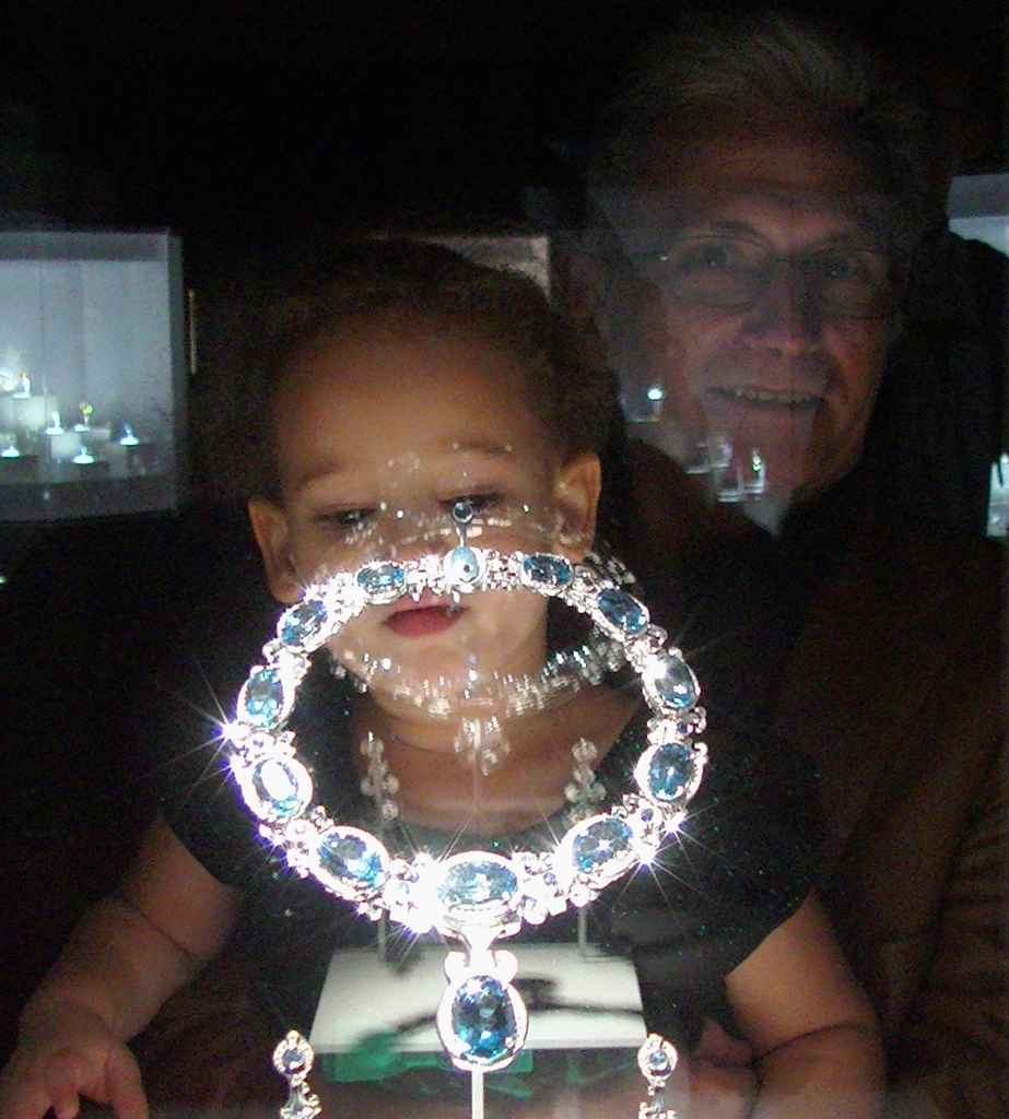 Aliyah looking at emerald and diamond necklace