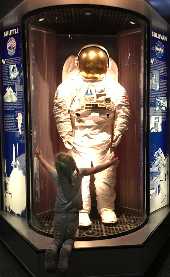 Aliyah hugging a space suit display