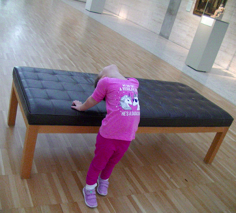 Aliyah demonstrates a correct back stretch using commonly available furniture